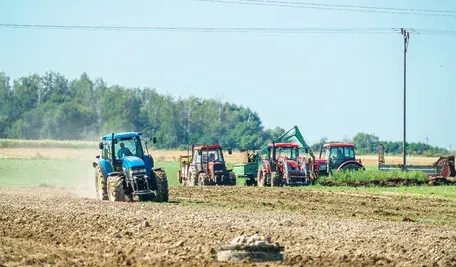 Traktory podczas prac polowych. Rolnicy muszą wspomagać się pożyczkami, by związać koniec z końcem