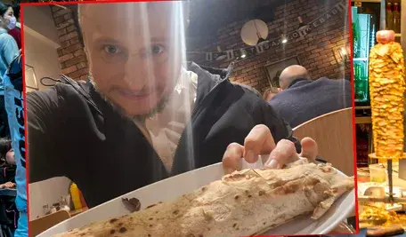 Poseł Platformy Obywatelskiej Krzysztof Brejza uśmiecha się, trzymając w dłoni kebab, zdjęcie opublikowane w mediach społecznościowych.