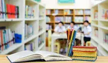 Widok na klase szkolna, na pierwszym planie przybory szkolne