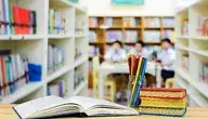 Widok na klase szkolna, na pierwszym planie przybory szkolne