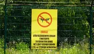 Tablica z napisem „Zakaz lotów bezzałogowymi statkami powietrznymi” na ogrodzeniu wojskowego terenu w Polsce. Zakaz używania dronów w rejonie ćwiczeń NATO i incydentów z niezidentyfikowanymi urządzeniami.