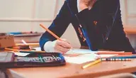 Dziecko siedzące samotnie w szkolnej ławce, skupione i zamyślone