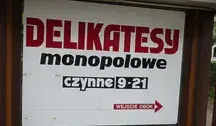 Szyld sklepu z alkoholem i napisem „Delikatesy monopolowe” ilustrujący spadek spożycia alkoholu w Polsce według badań CBOS