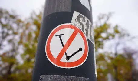 Naklejka z zakazem hulajnóg elektrycznych na chodniku w Pradze, informująca o ograniczeniach w centrum miasta.