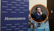 Szyld partii Nowoczesna oraz twarz Adama Szłapki, przewodniczącego ugrupowania i rzecznika rządu, w kontekście decyzji o likwidacji partii i jej problemów finansowych.