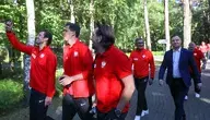 Grzegorz Krychowiak w towarzystwie Wojciecha Szczęsnego i Tomasza Iwana na spotkaniu z prezydentem Andrzejem Dudą. Piłkarze reprezentacji Polski spacerują w towarzystwie prezydenta RP w ośrodku treningowym. Zawodnicy w czerwonych dresach kadry narodowej robią wspólne zdjęcie podczas luźnej rozmowy w lesie.