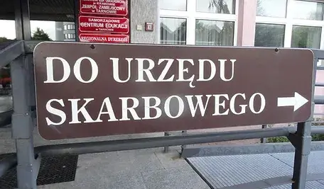 Drogowskaz wskazujący kierunek do urzędu skarbowego.