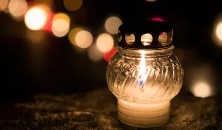 Jesienny cmentarz z zapalonym zniczem 1 listopada