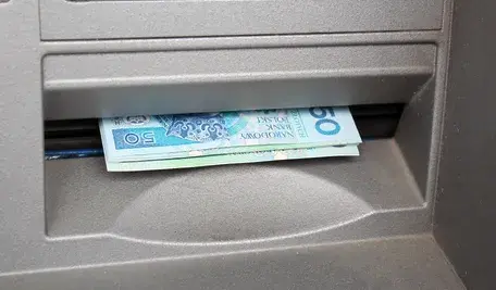 Z kont klientów jednego z komercyjnych banków zaczęły znikać pieniądze . Na zdjęciu gotówka wypłacana z bankomatu. 