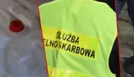 Funkcjonariusze Krajowej Administracji Skarbowej przy nielegalnej bimbrowni w gminie Mońki – widoczna aparatura do destylacji alkoholu, pojemniki z zacierem i butle gazowe zabezpieczone przez służby.