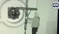 Nagranie z monitoringu pokazujące zamaskowanego włamywacza wewnątrz kościoła w Żorach, stojącego przy dużym krzyżu podczas aktu dewastacji.