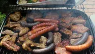 Mięsne kiełbasy, kotlety i skrzydełka z kurczaka grillowane na ruszcie. Zdjęcie ilustruje decyzję Parlamentu Europejskiego, zgodnie z którą nazwy takie jak „stek”, „kotlet” czy „kiełbasa” będą zarezerwowane wyłącznie dla produktów zawierających mięso.