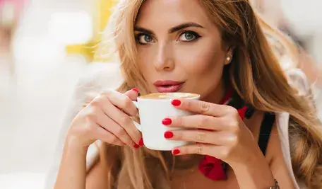 Piękna blondynka z kawą, w tle brazylijska susza i spekulanci windują ceny kawy