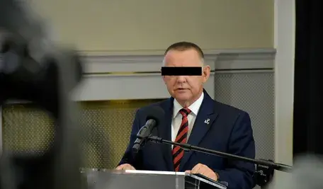 Były prezes Najwyższej Izby Kontroli Marian B. z zasłoniętymi oczami podczas publikacji informacji o postawionych mu zarzutach