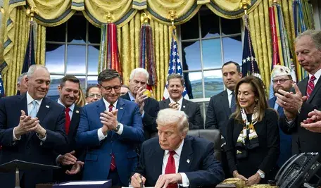 Prezydent Donald Trump podpisuje ustawę budżetową kończącą najdłuższe w historii USA zamknięcie rządu, w tle amerykańska flaga i dokumenty Kongresu, Waszyngton, listopad 2025