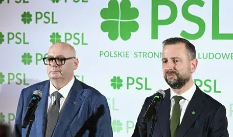 Piotr Zgorzelski i Władysław Kosiniak-Kamysz przemawiają przy mikrofonach podczas konferencji prasowej PSL, na tle tablicy z logo Polskiego Stronnictwa Ludowego.
