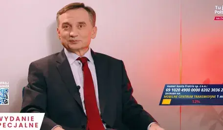 Zbigniew Ziobro w garniturze siedzi w studiu telewizyjnym podczas programu na żywo