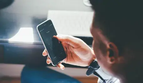 Na zdjęciu mężczyzna korzystający z telefonu. 