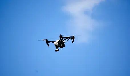 Dron unoszący się nad bazą wojskową – symbol rosnącego zagrożenia i incydentów z udziałem niezidentyfikowany