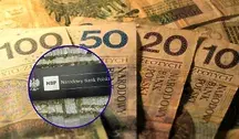 Polskie banknoty o nominałach 100, 50, 20 i 10 zł rozłożone na stole; nałożone okrągłe zbliżenie przedstawia tabliczkę z logo Narodowego Banku Polskiego na tle kamiennej ściany.
