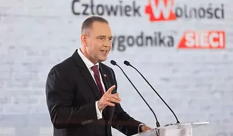 Prezydent Karol Nawrocki przemawia przy podium z dwoma mikrofonami podczas uroczystego wydarzenia. W tle widoczny jest baner z napisem ‘Człowiek Wolności Tygodnika Sieci’