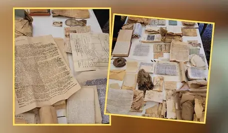 Zestaw odnalezionych podczas remontu na Saskiej Kępie dokumentów z okresu II wojny światowej ułożonych na stole. Widać stare gazety, formularze, notatki konspiracyjne, fotografie, legitymacje i inne zniszczone materiały papierowe pochodzące z tajnej skrytki.