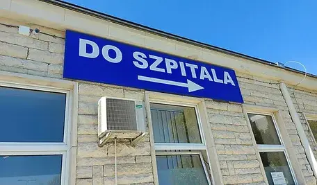 Napis „Do szpitala” na budynku placówki medycznej w Polsce.