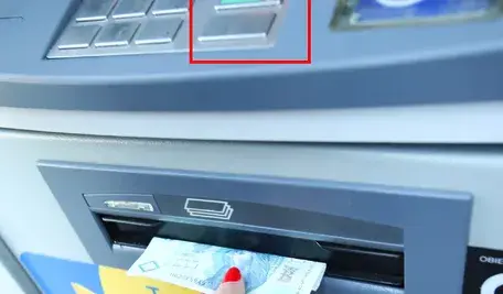 „Podejrzana nakładka na bankomacie i osoba odbierająca banknot – możliwy skimming podczas wypłaty pieniędzy.”