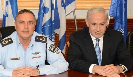 „Premier Izraela Benjamin Netanjahu podczas wystąpienia, stojący przy mównicy ministerialnej.”