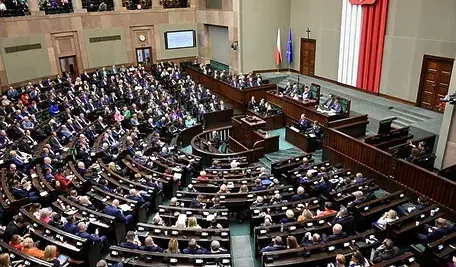 Sala obrad polskiego Sejmu wypełniona posłami podczas trwającej sesji plenarnej.