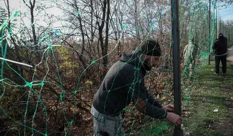 Ukraińscy żołnierze w Doniecku stawiają siatkę przeciwko dronom.
