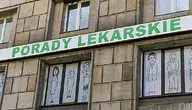 Budynek z szyldem „Porady lekarskie” na tle okien ozdobionych rysunkami postaci.