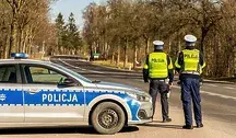 Dwaj policjanci w mundurach podczas kontroli drogowej.