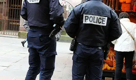 Dwóch policjantów w mundurach stojących na ulicy.