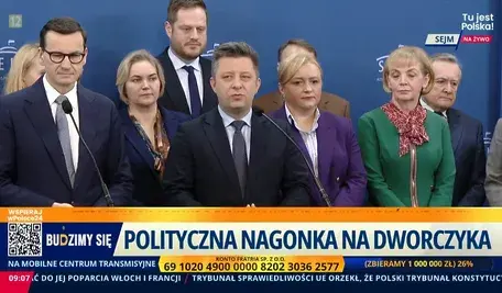 Konferencja prasowa Michała Dworczyka. Obok m. in. premier Mateusz Morawiecki i wicepremier Piotr Gliński oraz posłanka Anna Kwiecien w zielonym kostiumie i czerwonej apaszce