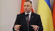Prezydent Karol Nawrocki podczas wystąpienia publicznego na tle flagi Polski i Ukrainy.