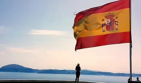 Hiszpańska flaga na tle oceanu. W Estremadurze lewica przegrała wybory, które uznano za prognostyk dla całego kraju. 