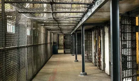 Korytarz w więzieniu, widok na puste cele.