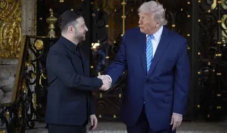 Prezydent USA Donald Trump i prezydent Ukrainy Wołodymyr Zełenski podają sobie dłoń na powitanie.