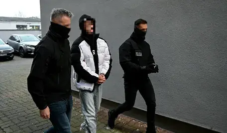 19-letni Alan G., oskarżony o brutalne morderstwo swojego współlokatora w Słupsku. prowadzony w kajdankach przez policjantów