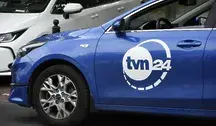 Samochód ekipowy TVN stojący przed siedzibą stacji — symbol działalności medialnej Warner Bros. Discovery w kontekście trwających rozmów o przejęciu firmy.