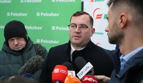 Minister rolnictwa Stefan Krajewski udziela wypowiedzi mediom przed mikrofonami.
