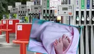 Stacja benzynowa z dystrybutorami paliwa, na pierwszym planie wstawione zdjęcie stópek noworodka.