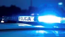 Radiowóz policyjny z włączoną sygnalizacją świetlną.