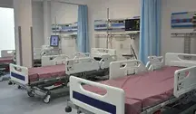 Pusta sala szpitalna z kilkoma łóżkami, szafkami nocnymi i zasłoniętymi oknami. Zdjęcie ilustruje zawieszenie Oddziału Chirurgii Ogólnej w szpitalu w Nakle nad Notecią z powodu braku lekarzy specjalistów.