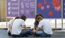 Grupa uczniów siedzących na zewnątrz przed tablicami informacyjnymi – ilustracja artykułu o kontrowersyjnym dofinansowaniu wakacji w gminie Baranów uzależnionym od uczestnictwa w zajęciach z edukacji zdrowotnej.