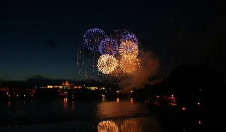 Pokaz fajerwerków nad miastem w noc sylwestrową, kolorowe eksplozje na tle nocnego nieba