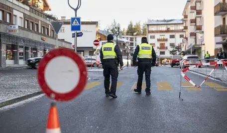 Dwóch policjantów zabezpieczających teren pożaru w szwajcarskim kurorcie.