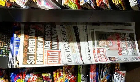gazety leżące na stojaku w niemieckim kiosku