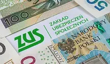 Kartka z logo Zakładu Ubezpieczeń Społecznych przykryta banknotami.